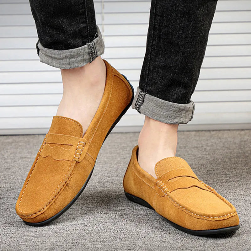 Men's solid colour suede loafers with round toe and rubber sole on a neutral background.