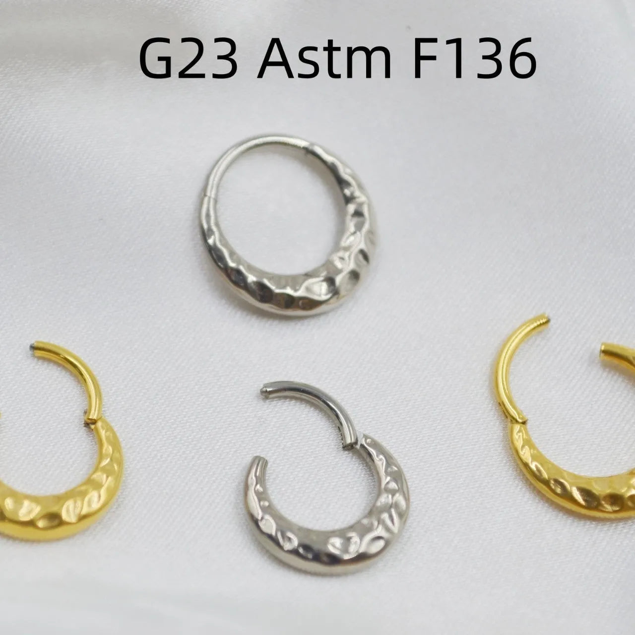 Close-up of a titanium concave-convex nose ring in gold finish, showing its textured profile and 1.2mm thickness.