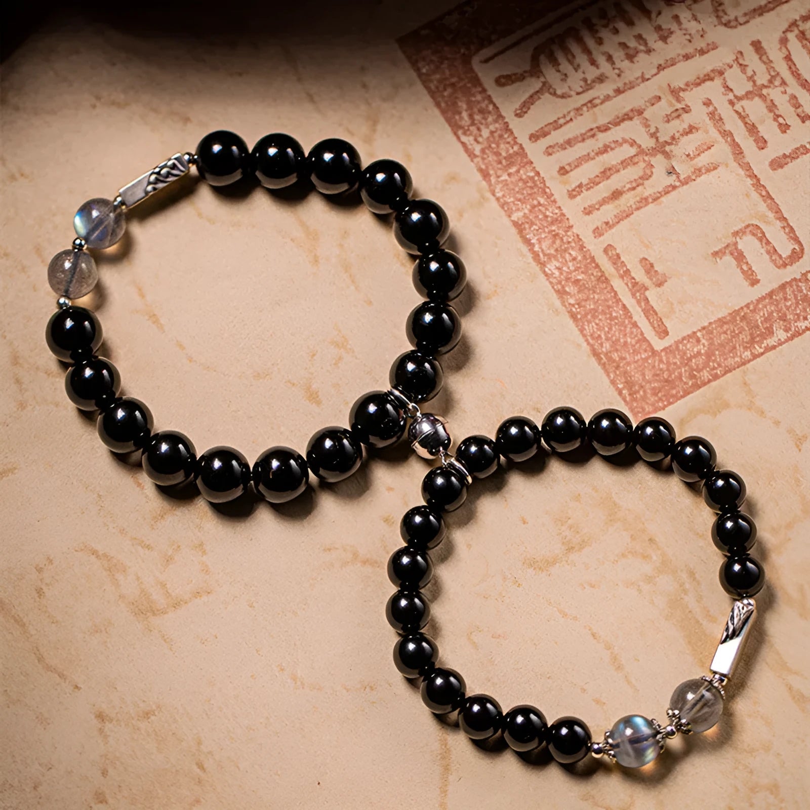 Obsidian couple bracelet DIY set with 8mm and 10mm Buddha beads on adjustable string.