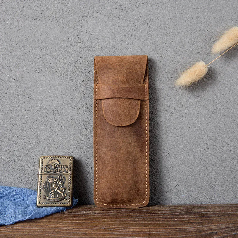 Brown leather pencil case with zip opening on a plain background