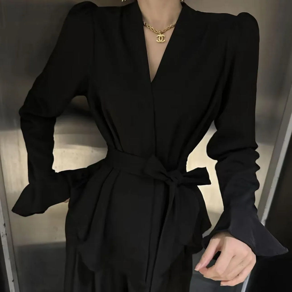 Women's black French-style shirt with irregular collar, long bell sleeves, and a tied front detail.
