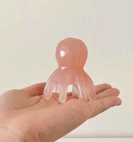 Pink octopus-shaped massage comb for facial meridian stimulation with storage bag