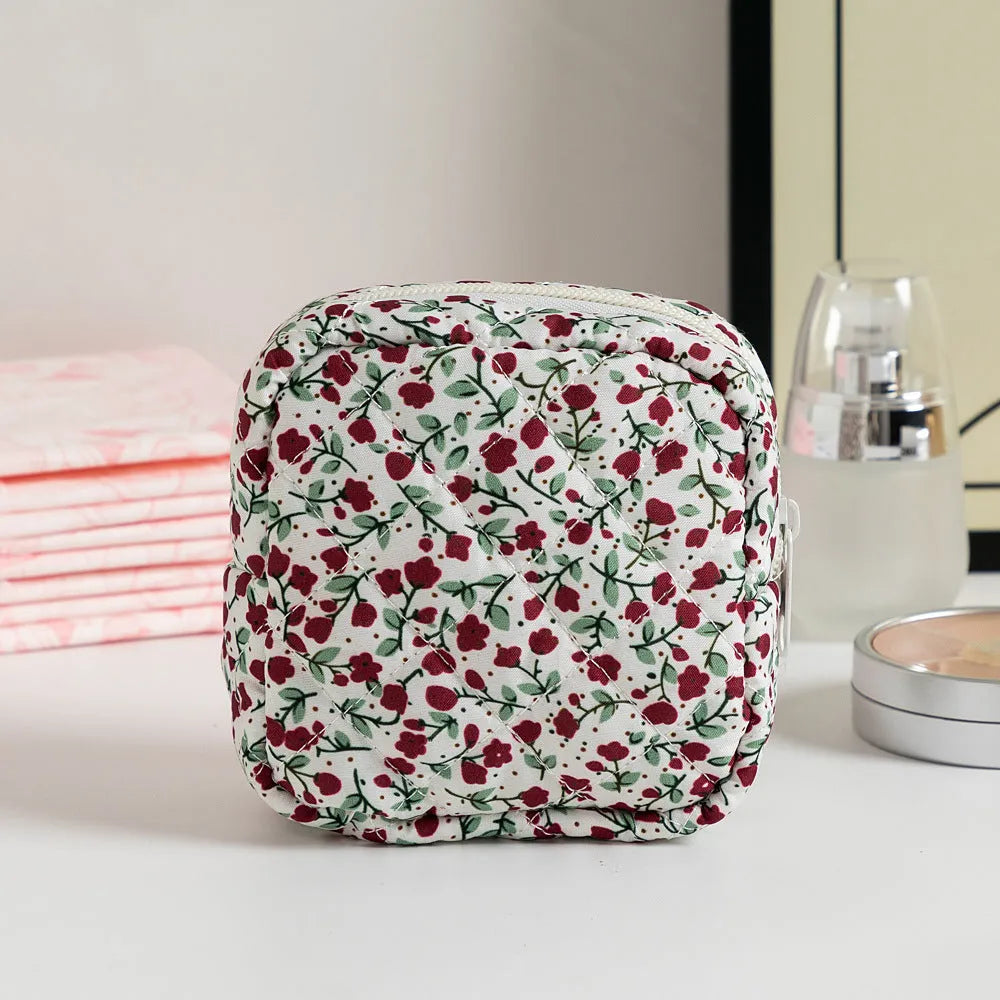 Yellow floral polyester key storage bag with sewing thread detail next to red small flower design variant.