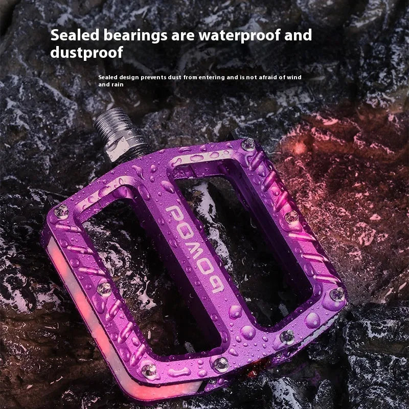 Bicycle pedals with LED lights in purple, black, titanium, red, and gold colour options