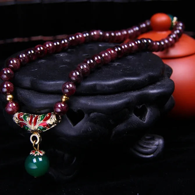 Natural garnet bracelet with 7mm beads and golden toad design on wrist