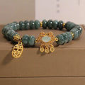 Close-up of a women's bracelet with emerald green jade abacus beads and a metallic safety lock clasp.