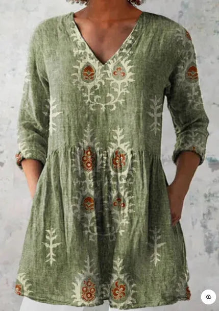 A woman wearing a loose-fitting printed dress with 3/4 sleeves and a wide waist.
