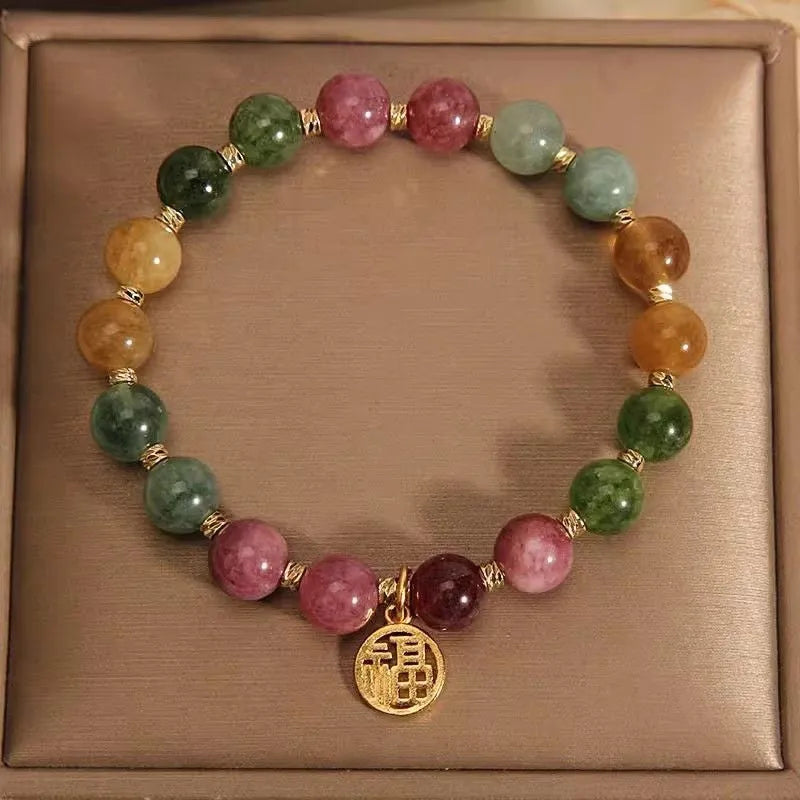 Natural colour tourmaline bracelet with floral and fu character charms on geometric electroplated chain