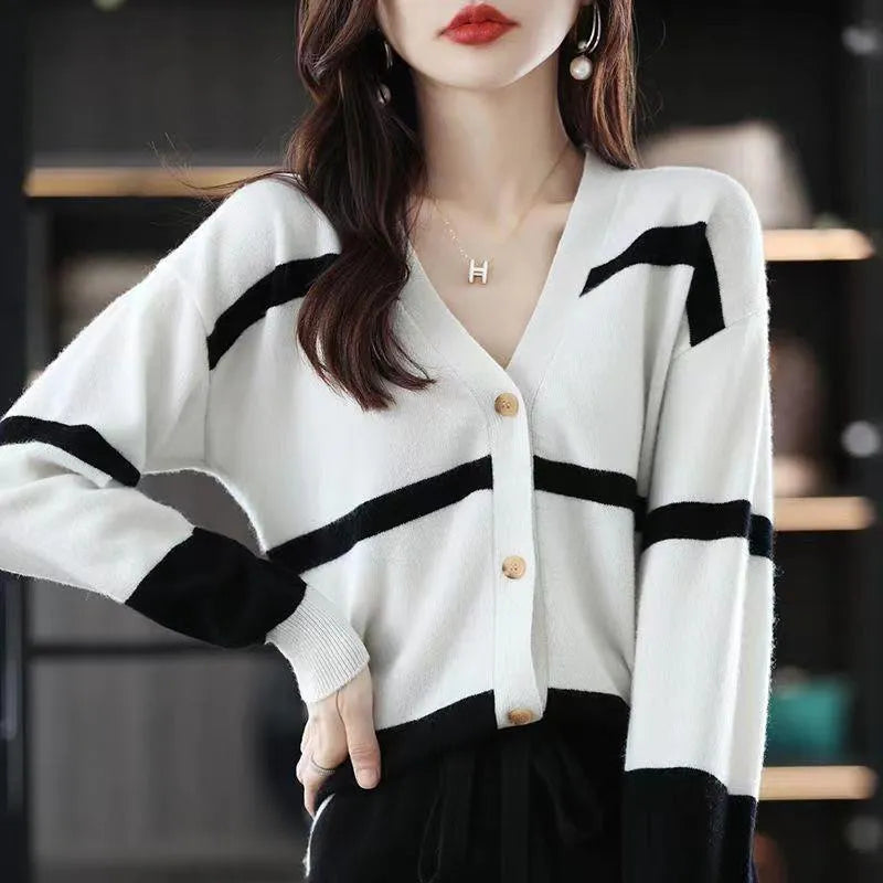 Women's black and white striped V-neck knitted cardigan with 3D pattern on a hanger.