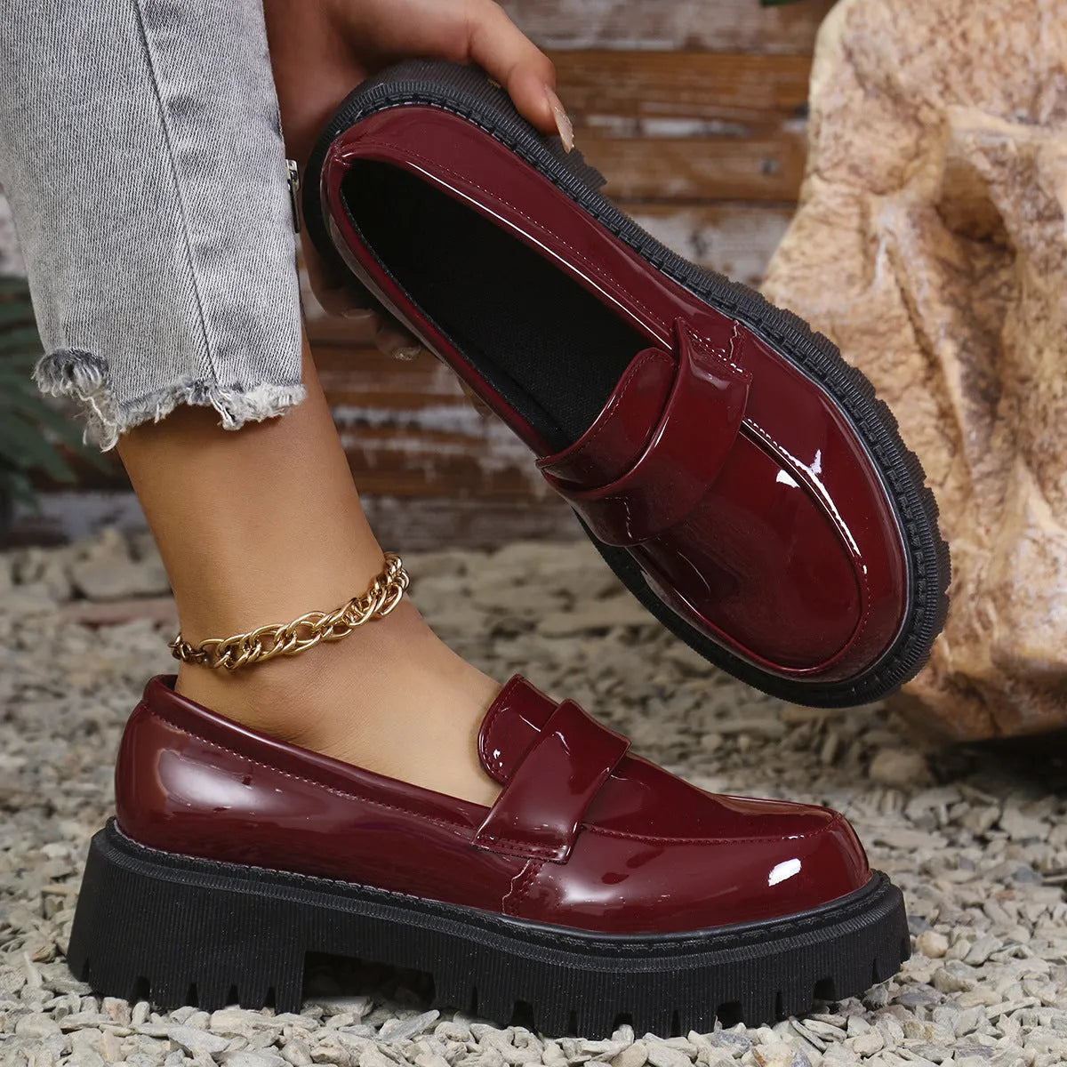 Women's black slip-on loafers with a chunky platform heel and rubber sole on a neutral background.