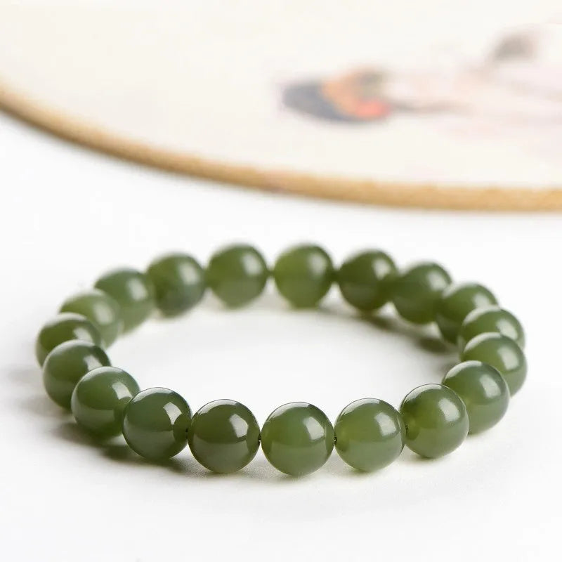 Polished Hetian jade bead bracelet in ice-like clear water colour on a wrist.