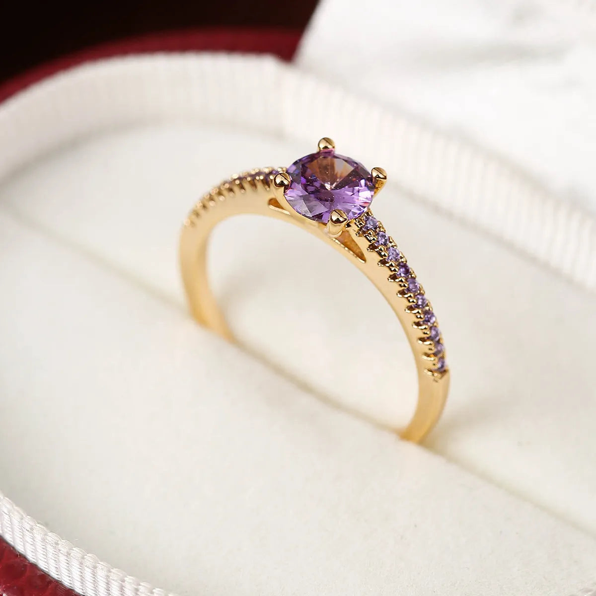 Hexagonal geometric copper ring with zircon electroplating in a gold rose red finish on a hand.