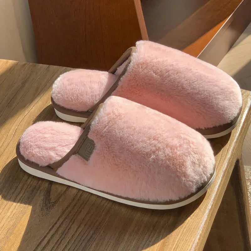 Solid colour PVC plush winter house slippers on a wooden floor.