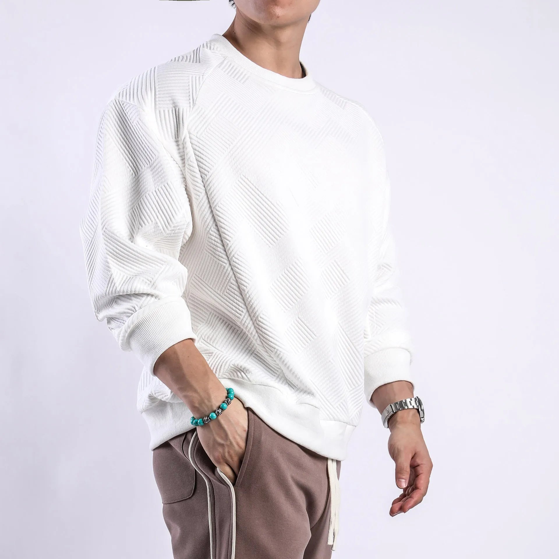 Man wearing a loose-fit army green twill jacquard long-sleeved pullover sweater.