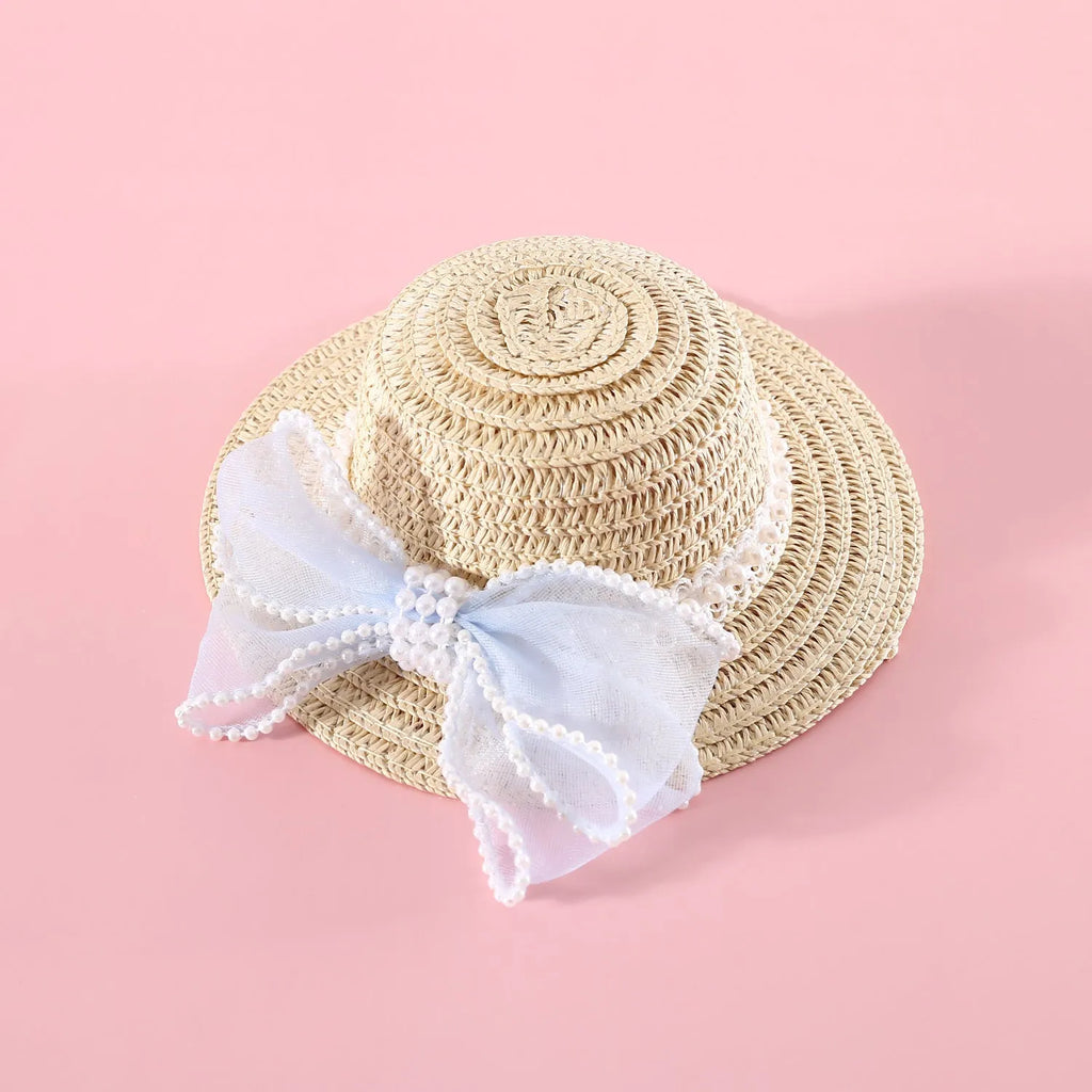 Cat wearing a woven straw hat with a pearl bow decoration in a princess style.