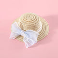 Cat wearing a woven straw hat with a pearl bow decoration in a princess style.