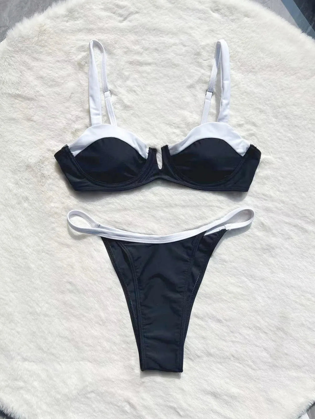 Women's black low waist bikini swimsuit with stitching detail and split leg design