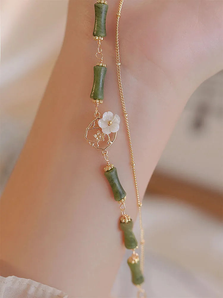 Natural olivine gemstone bracelet for women with double layer design and twin bells of Ireland charms.