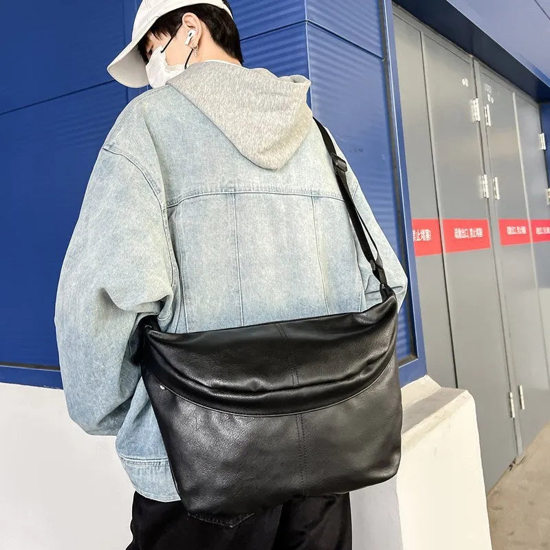 Retro large capacity men's crossbody bag in brown PU leather with zipper closure on white background.
