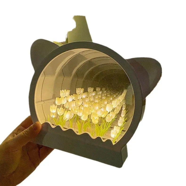 Handmade DIY cat head shaped night lamp surrounded by colourful tulip flowers on a table.