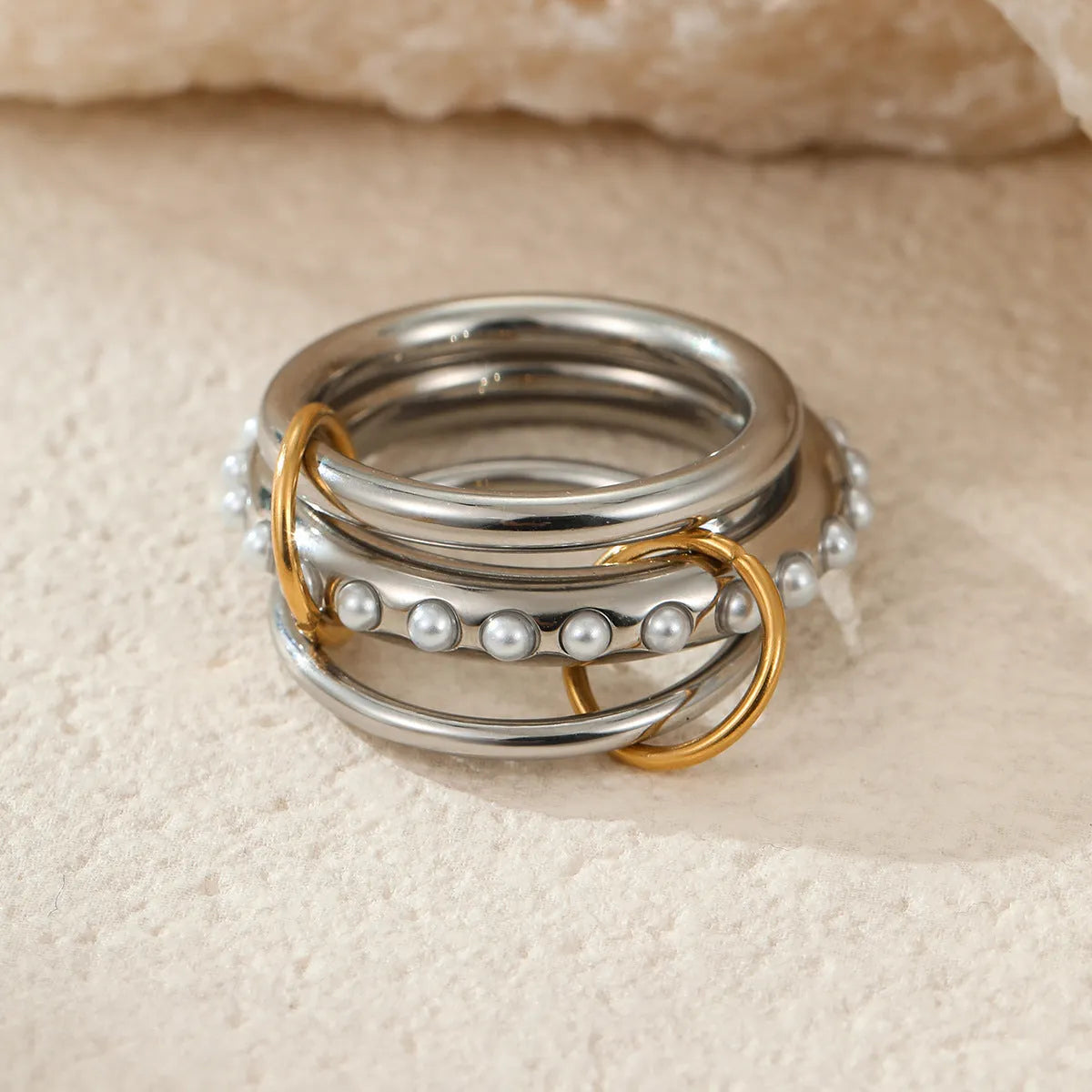 Stacked gold plated stainless steel rings showing layered jewellery look on female hand