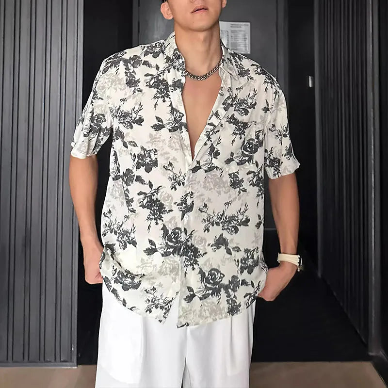 Man wearing a loose black floral print casual short sleeve shirt.
