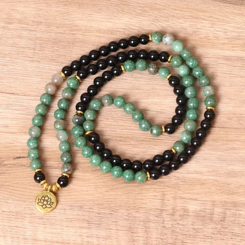 Green and black elastic beaded long bracelet with alloy components stretched on wrist