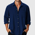 Man wearing a loose fit long sleeve beach shirt with a stand collar in a solid colour.