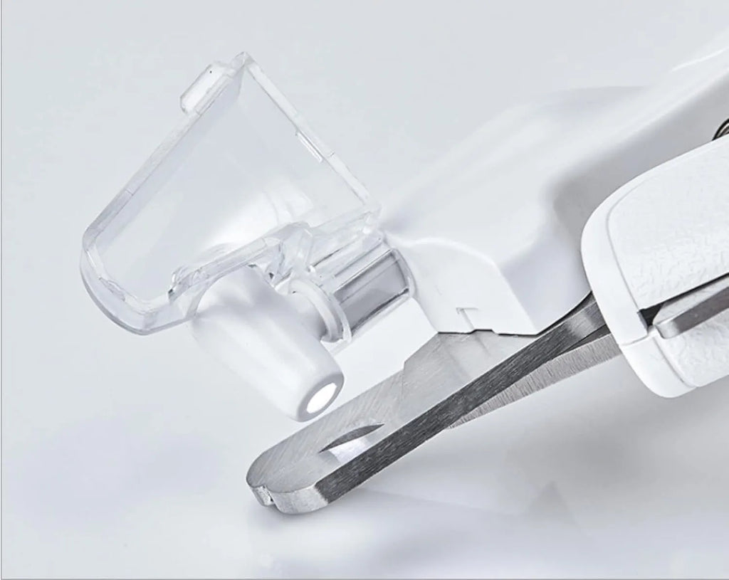 White pet nail clippers with LED light and a transparent anti-splash guard, shown with a nail file.