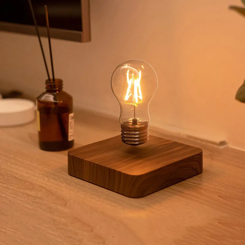 Creative minimal self-rotating maglev bulb with ABS base and warm yellow light on a desk