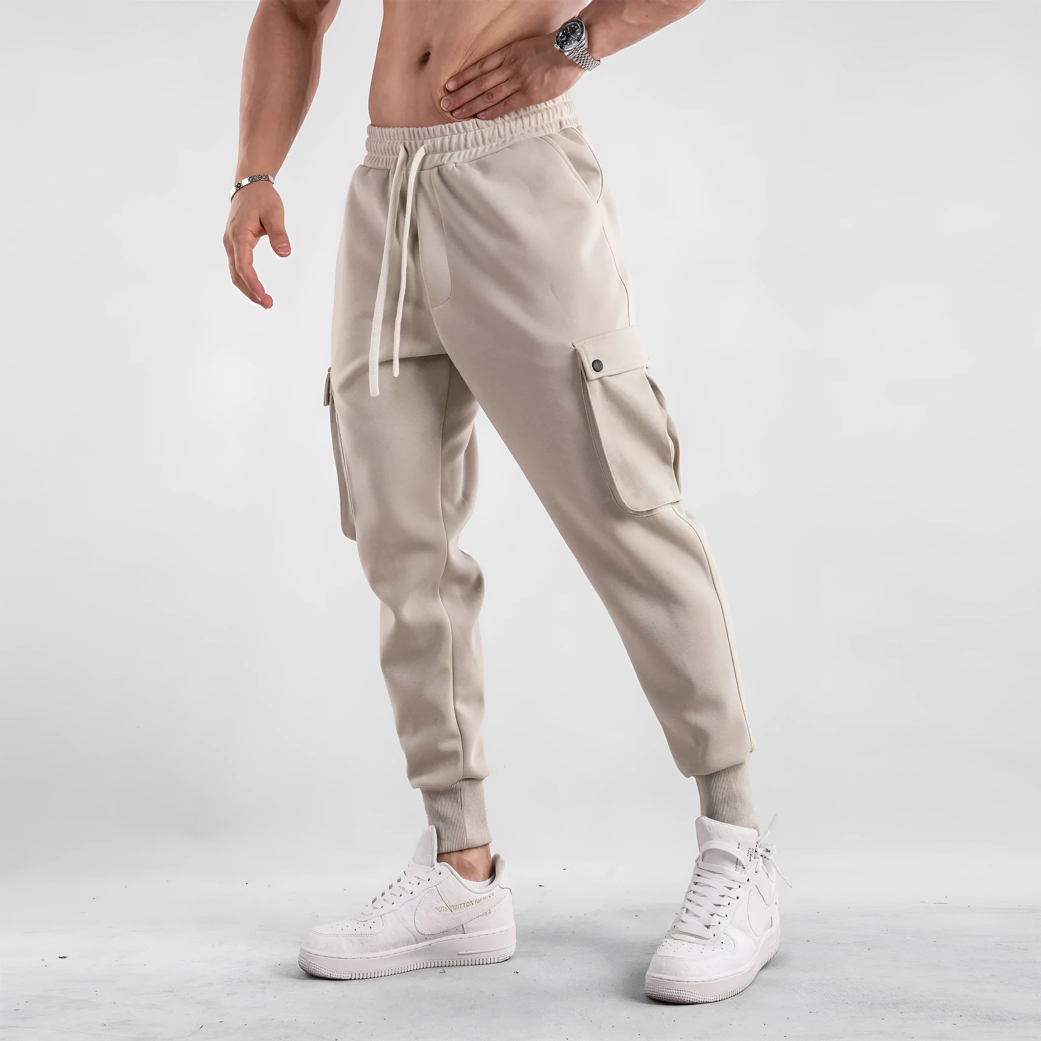 Men's loose-fit light grey cotton sports trousers with ankle tie and side pockets.