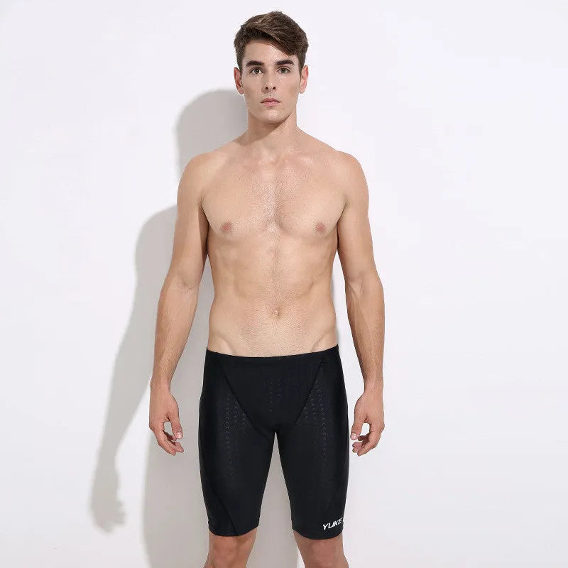 Men's black five-piece swimming set including trunks, goggles, cap, ear plugs, nose clip, and carry bag laid out flat.