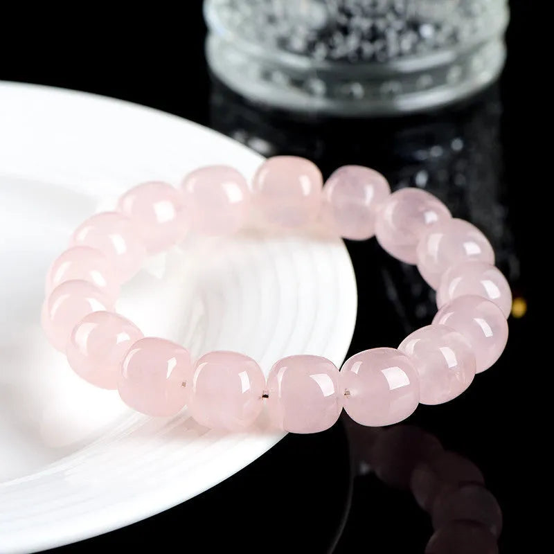 Pink crystal barrel bead bracelet with 11-12mm geometric beads on natural background