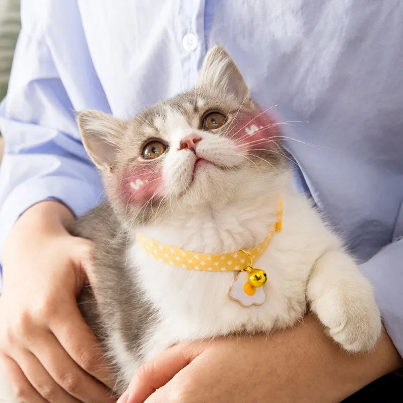 Green adjustable pet collar with a metal bell pendant and a matching bow tie on a white background.