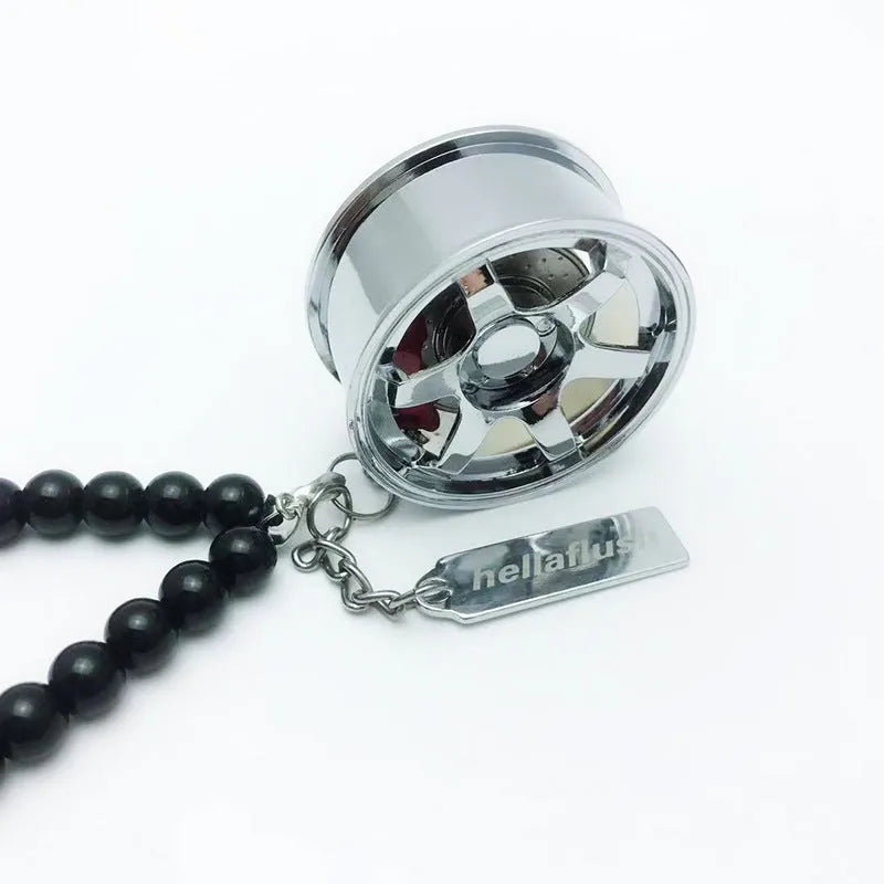 Stainless steel car tyre ornament with crystal glass bead chain hanging from a rearview mirror