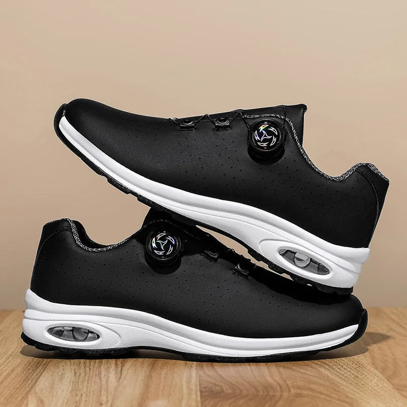 Low-top black and white tennis shoes with mesh uppers, cross shoulder straps, and a flat composite sole.