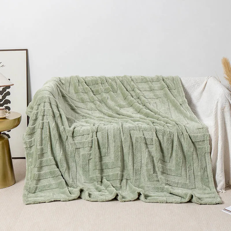 Thick square coral fleece blanket in a solid colour, draped over a sofa.