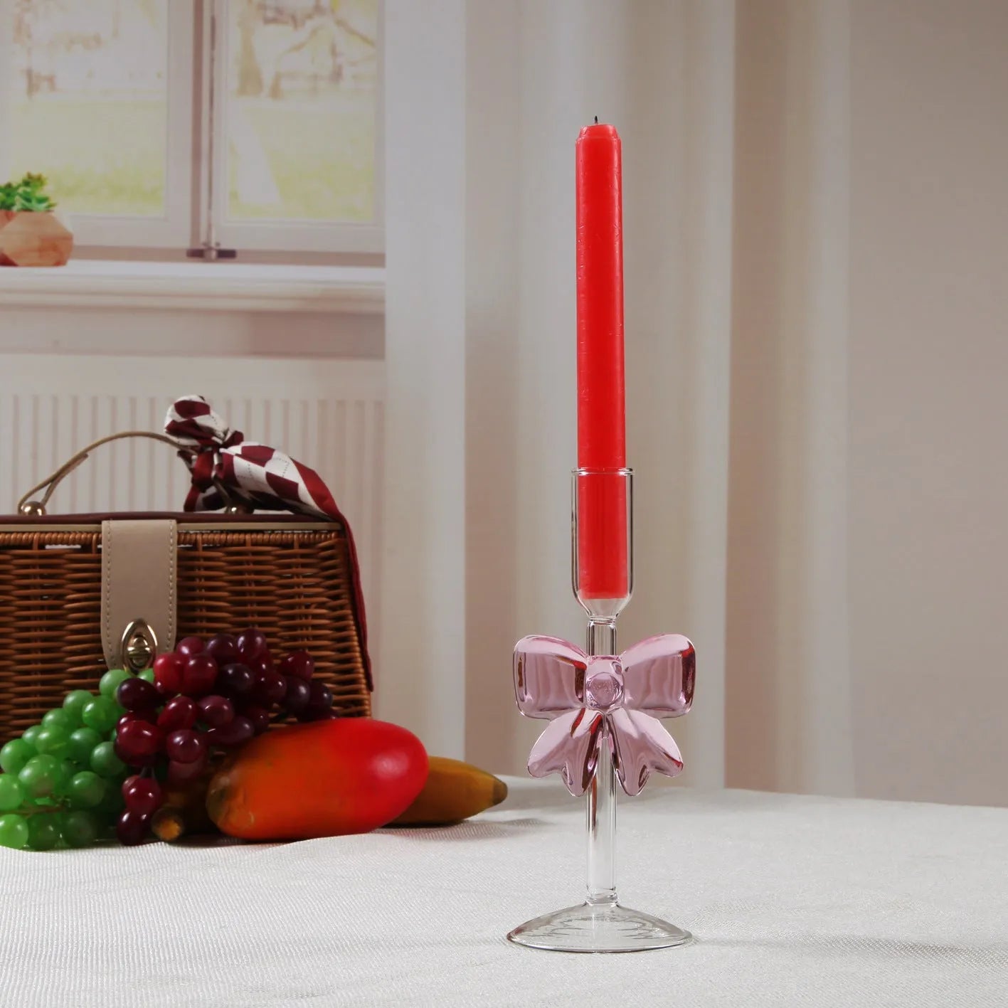 Set of three clear borosilicate glass candlesticks with large bow decorations on a table