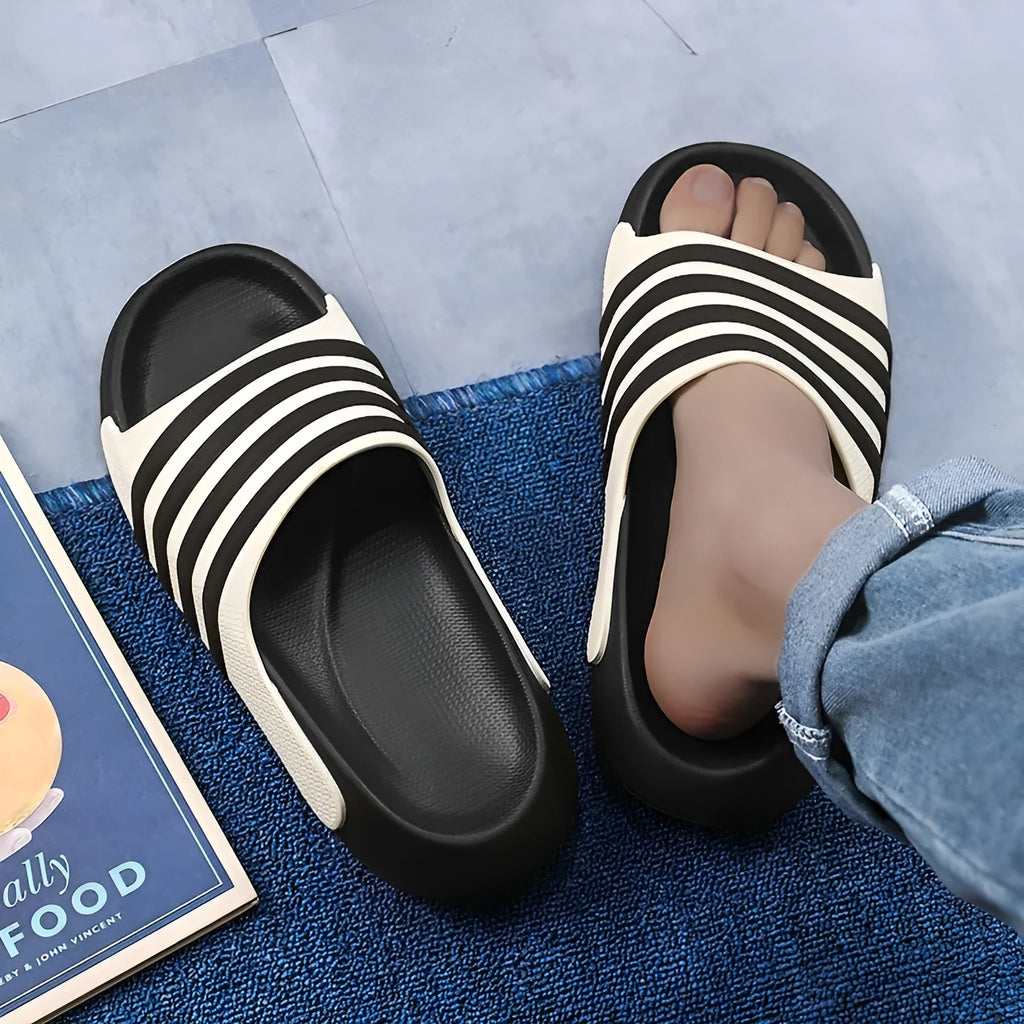 A pair of casual unisex slippers with an EVA sole and PVC upper, shown in a two-tone colour option.