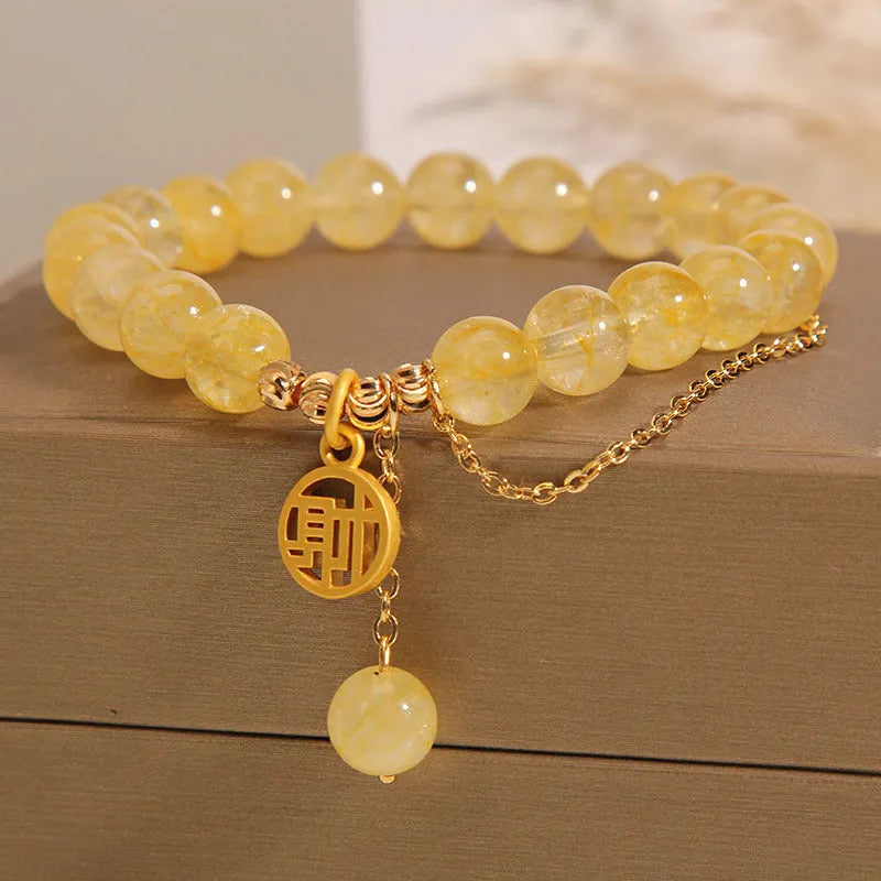 Natural citrine stone bracelet with an electroplated Chinese character tassel charm.