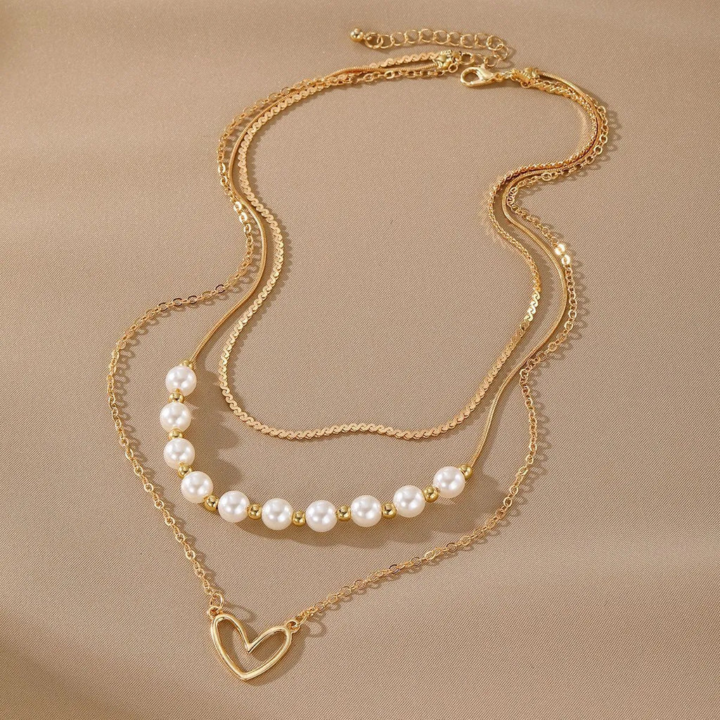 Vintage gold heart pendant necklace with pearl chain detailing showing adjustable length feature