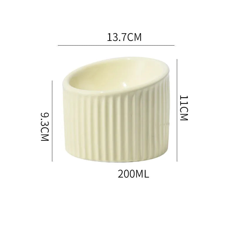 Elevated ceramic cat bowl in green, showing tilted design and raised height for feeding.