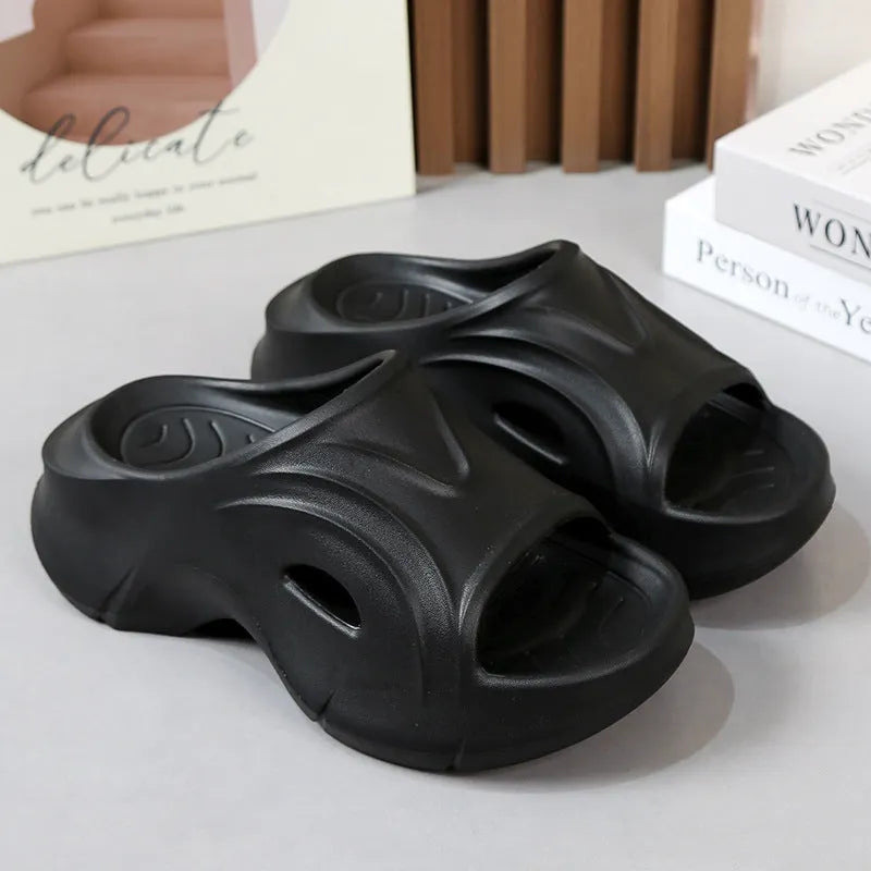Women's thick-soled EVA slippers in rose red colour on a sandy beach.