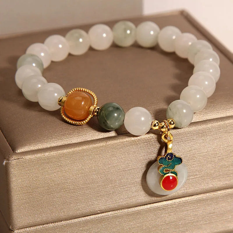 Close-up of a women's ice jade bracelet with a peace jade buckle and pearl decorative elements.