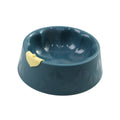 Green plastic double pet bowl for dog and cat food and water on a white surface