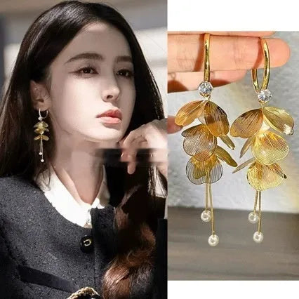Gold floral petal pearl fringe drop earrings with electroplated alloy finish on neutral background