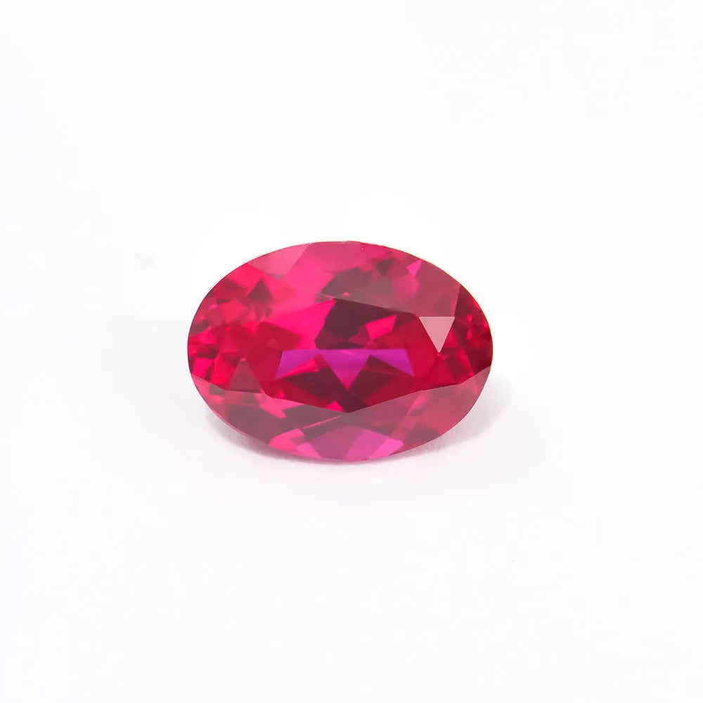 Loose cultivated pigeon blood red ruby gemstone in a princess cut on a grey background.