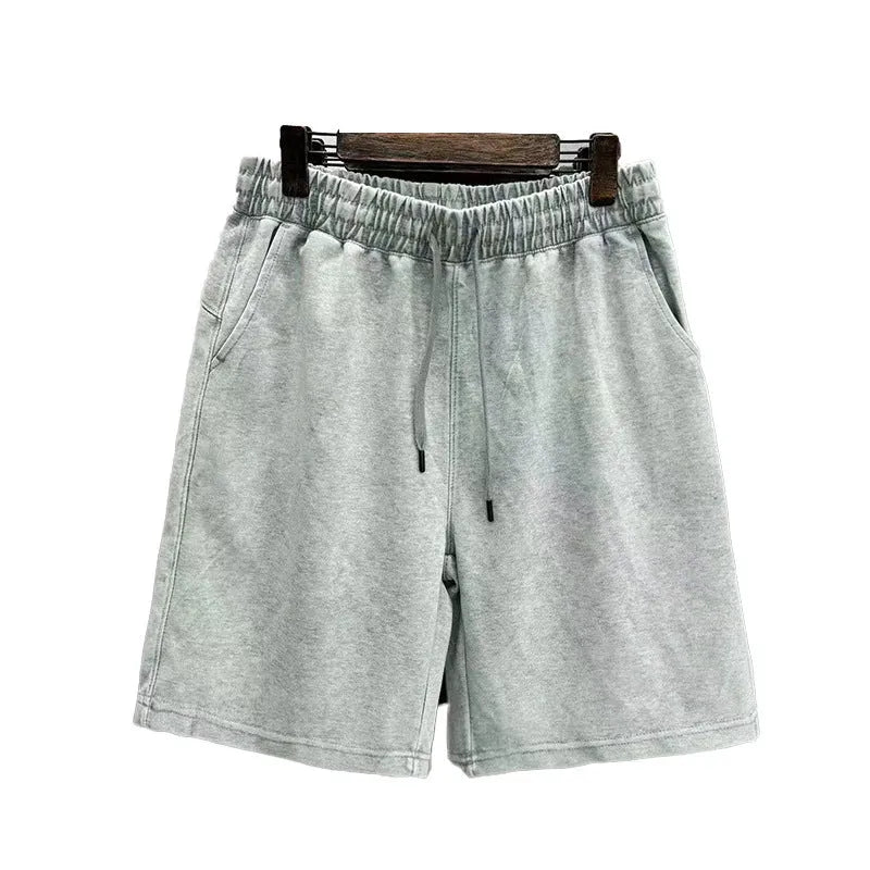 Men's solid colour cotton shorts with distressed detailing on the leg, shown in a loose, straight-leg fit.