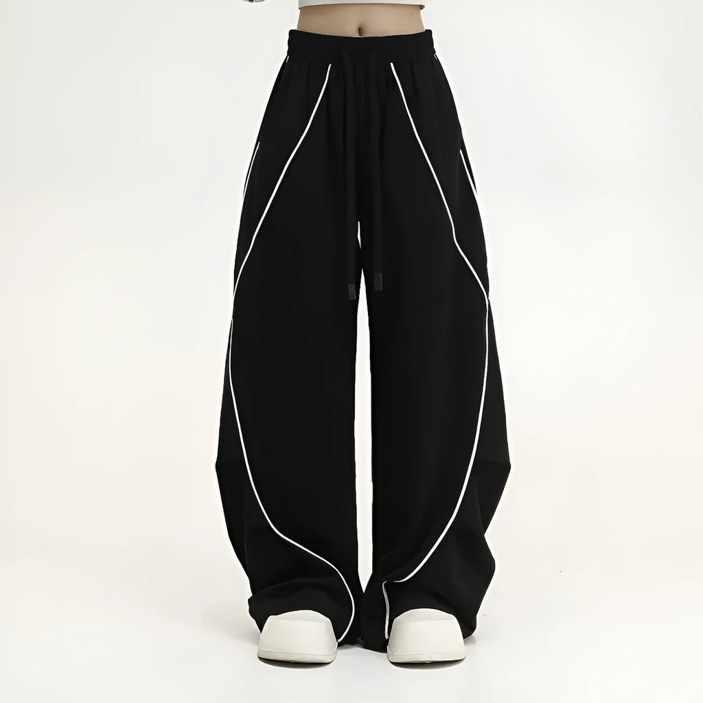 Black pleated wide-leg hip hop sports trousers on a hanger, showing loose fit and striped pattern.