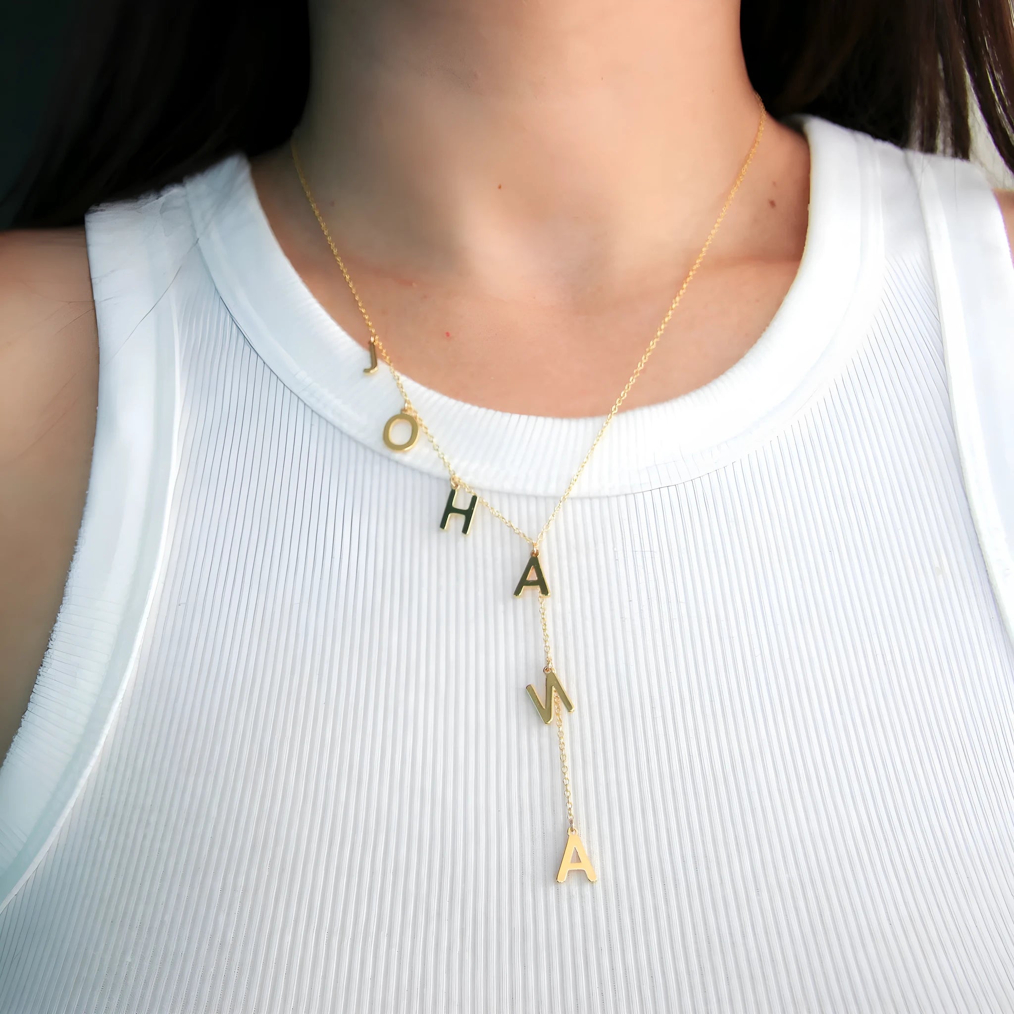 Gold lariat name necklace with bubble letters on adjustable chain, isolated on white background